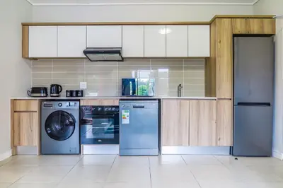 a kitchen with white cabinets and a dishwasher at Insaka 1 The Blyde Crystal Lagoon Experience in Pretoria