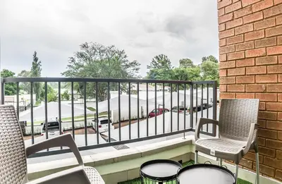 a balcony with chairs and a fence and a parking lot at Insaka 1 The Blyde Crystal Lagoon Experience in Pretoria