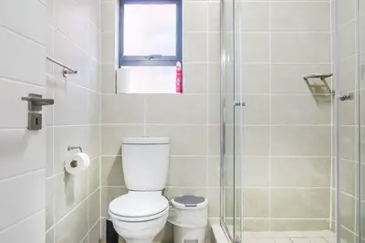 a bathroom with a toilet and a glass shower at Insaka 2 The Blyde Crystal Lagoon Experience in Pretoria