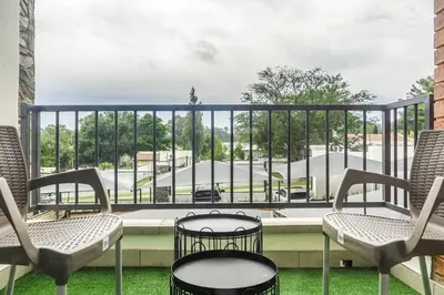 a balcony with chairs and a view of a building at Insaka 2 The Blyde Crystal Lagoon Experience in Pretoria