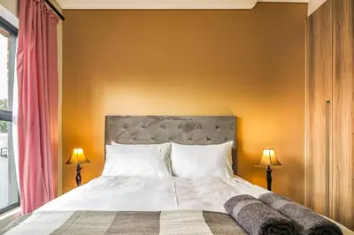 a bedroom with a large bed and two lamps at Insaka 2 The Blyde Crystal Lagoon Experience in Pretoria