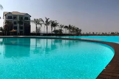 a large swimming pool with blue water and palm trees at Insaka 2 The Blyde Crystal Lagoon Experience in Pretoria