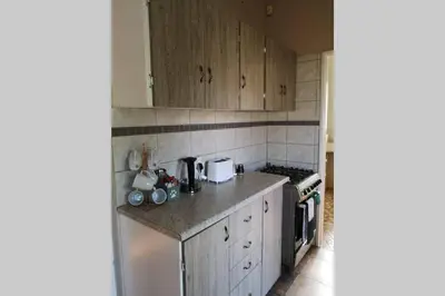 a kitchen with wooden cabinets and a counter top at Ducks Nest in Malelane