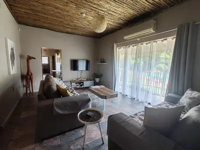a living room with a couch and a table at Ducks Nest in Malelane