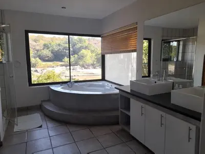 a bathroom with a tub and two sinks and a window at Bushriver Lodge in Mica
