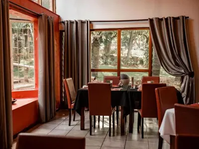 a dining room with a table and chairs and windows at Hotel 247 @ White River in White River