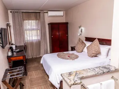 a hotel room with a white bed and a window at Hotel 247 @ White River in White River