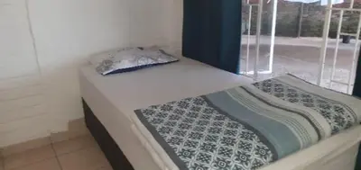 a bed in a room next to a window at Thullyteams guesthouse in Tzaneen