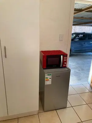 a microwave sitting on top of a refrigerator at Thullyteams guesthouse in Tzaneen