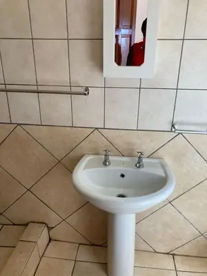a bathroom with a white sink and a mirror at Thullyteams guesthouse in Tzaneen