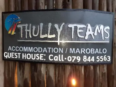 a sign on the side of a wooden wall at Thullyteams guesthouse in Tzaneen