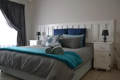 a bedroom with a large bed with two towels on it at The Open Door Guest Suite in Modimolle