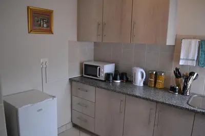 a kitchen with a counter with a microwave and a refrigerator at The Open Door Guest Suite in Modimolle