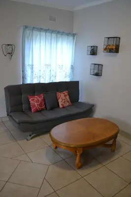 a living room with a couch and a coffee table at The Open Door Guest Suite in Modimolle