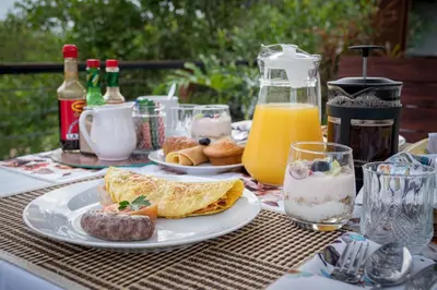 a table with a plate of breakfast foods and drinks at Gem In The Bush Lodge in Hoedspruit