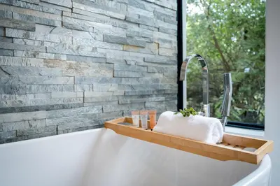 a bathroom with a bath tub with a sink at Gem In The Bush Lodge in Hoedspruit