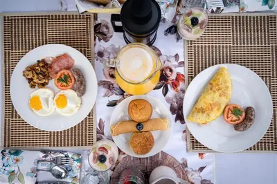 a table with plates of breakfast foods and a cup of coffee at Gem In The Bush Lodge in Hoedspruit