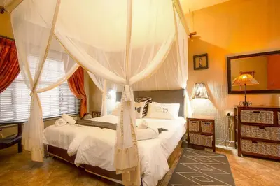 a bedroom with a bed with a canopy at Khaya Romantica - Bush getaway in Marloth Park