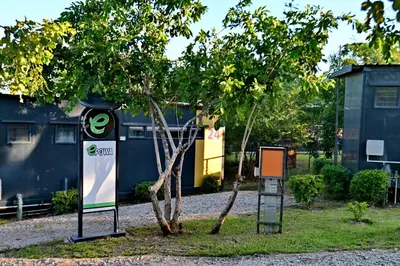 two signs next to a tree and a building at SleepOver Kruger Gate in Skukuza