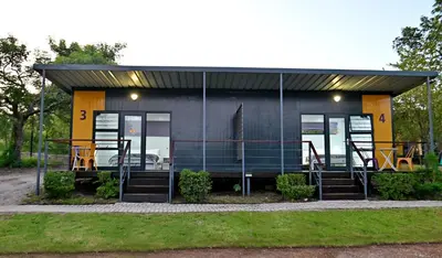 a tiny house with a black and yellow exterior at SleepOver Kruger Gate in Skukuza