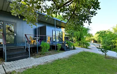 a house with yellow chairs on the porch of it at SleepOver Kruger Gate in Skukuza