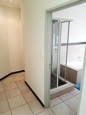 a bathroom with a shower and a glass door at NST City Apartments @ 9 Joubert in Nelspruit