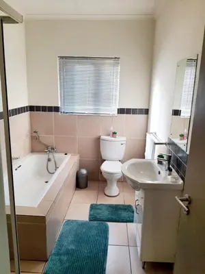 a bathroom with a tub and a toilet and a sink at NST City Apartments @ 9 Joubert in Nelspruit