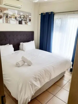 a white bed with a towel on top of it at NST City Apartments @ 9 Joubert in Nelspruit