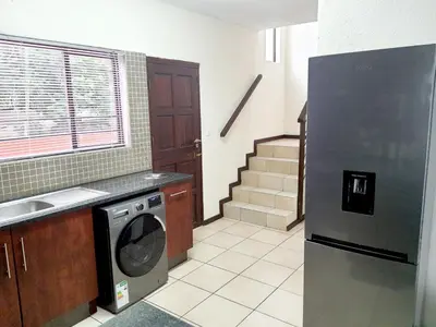 a kitchen with a refrigerator and a dishwasher at NST City Apartments @ 9 Joubert in Nelspruit
