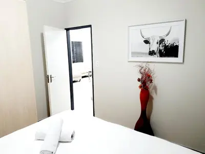 a bathroom with a mirror and a deer picture on the wall at NST City Apartments @ Casalinga Villa in Nelspruit