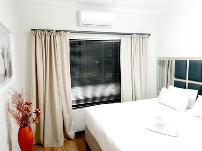a bedroom with two beds and a window at NST City Apartments @ Casalinga Villa in Nelspruit