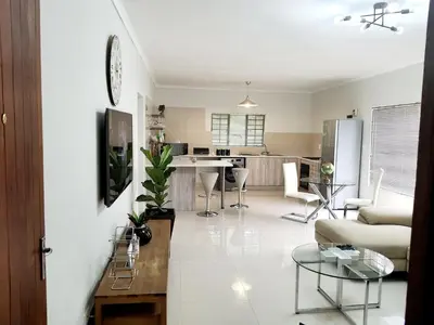 a living room and kitchen with a couch and a table at NST City Apartments @ Casalinga Villa in Nelspruit