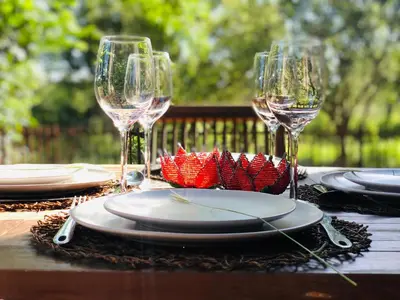 a table with two wine glasses and plates on it at Ndoto Cottage in Hoedspruit