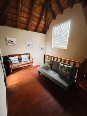 a living room with a couch and a window at Ndoto Cottage in Hoedspruit