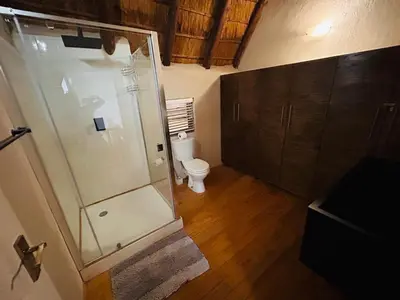a bathroom with a shower and a toilet at Ndoto Cottage in Hoedspruit