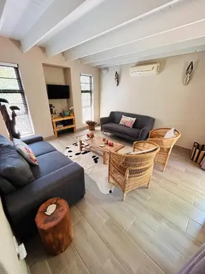 a living room with a couch and a table at Ndoto Cottage in Hoedspruit