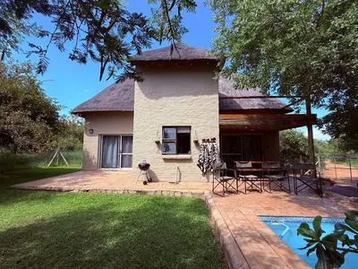 a building with a table and chairs in a yard at Ndoto Cottage in Hoedspruit