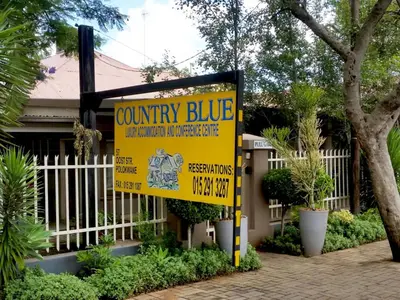 a yellow county blue sign in front of a house at Country Blue Luxury Guest House in Polokwane