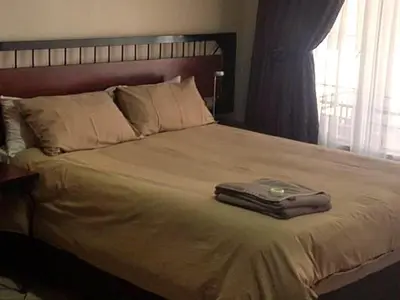 a bed with a suitcase sitting on top of it at Country Blue Luxury Guest House in Polokwane