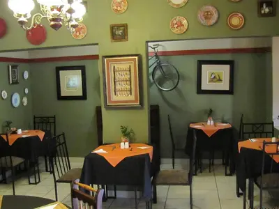 a restaurant with tables and chairs and a bike on the wall at Country Blue Luxury Guest House in Polokwane