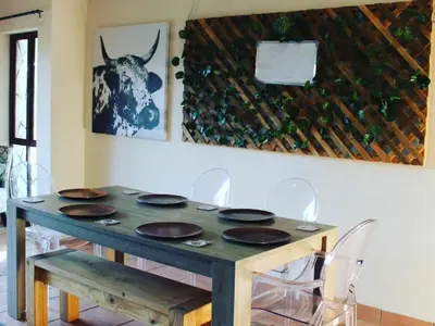 a wooden table with chairs in a dining room at Patogeng Self Catering - Da Gama Dam view in White River