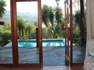 a door to a balcony with a view of a pool at Patogeng Self Catering - Da Gama Dam view in White River
