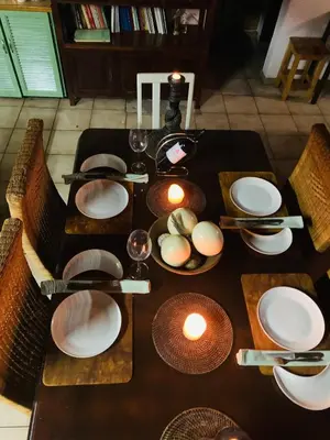 a wooden table with plates and glasses on it at Farm Vibes Guest House in Brits