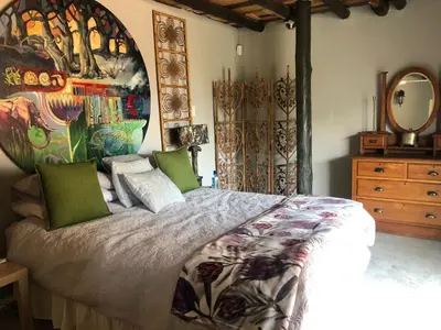 a bedroom with a bed and a painting on the wall at Farm Vibes Guest House in Brits