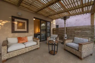 a porch with two chairs and a couch and a table at Lodge 54 in Hoedspruit