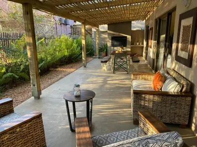 a patio with couches and a table and a television at Lodge 54 in Hoedspruit