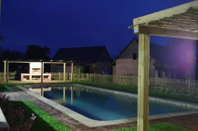 a swimming pool in a yard with a pergola at Lodge 54 in Hoedspruit