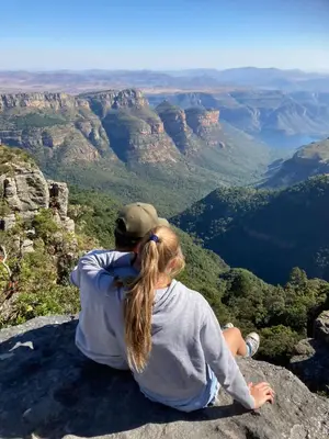 a woman sitting on the edge of a mountain looking at the view at Lodge 54 in Hoedspruit