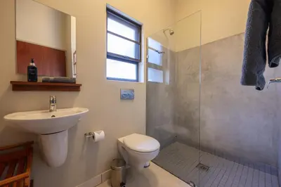a bathroom with a toilet and a sink and a shower at Lodge 54 in Hoedspruit