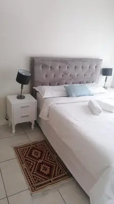 a bedroom with a large white bed and a nightstand at The Blyde Riverwalk Estate, Crystal Lagoon, Pretoria east in Pretoria
